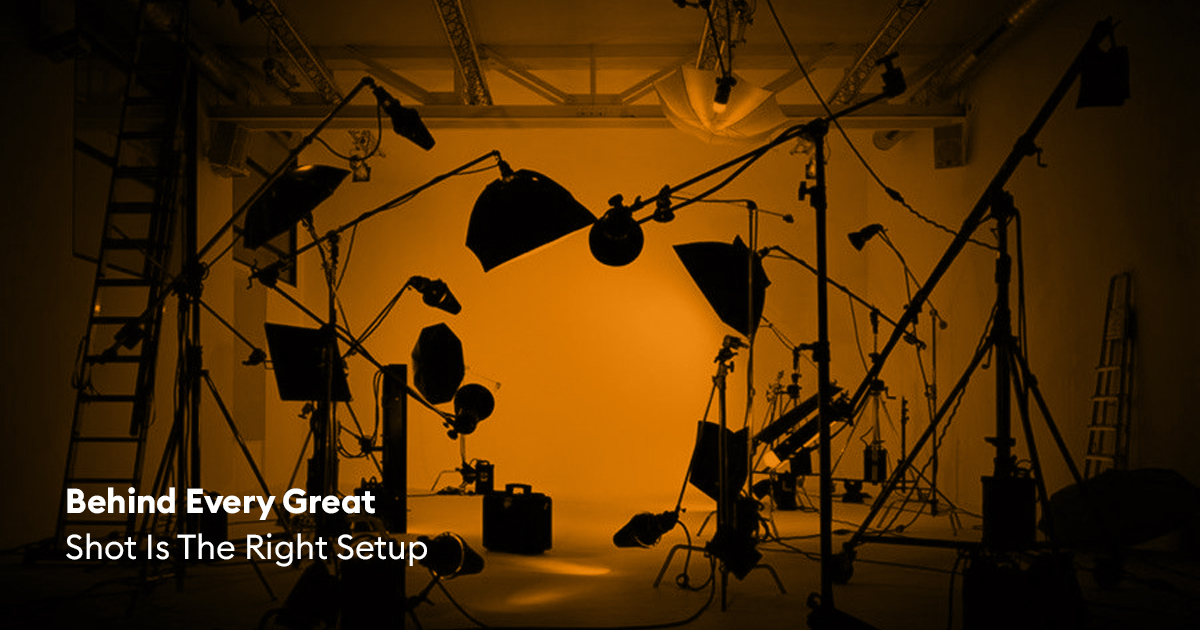 A professional studio setup featuring lighting stands, softboxes, camera equipment, and rigging arranged for a video or photography production shoot.